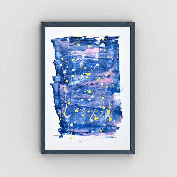 A framed abstract art featuring textured blue, purple, and pink brushstrokes with yellow paint splatters, set in a dark gray frame against a light gray wall.