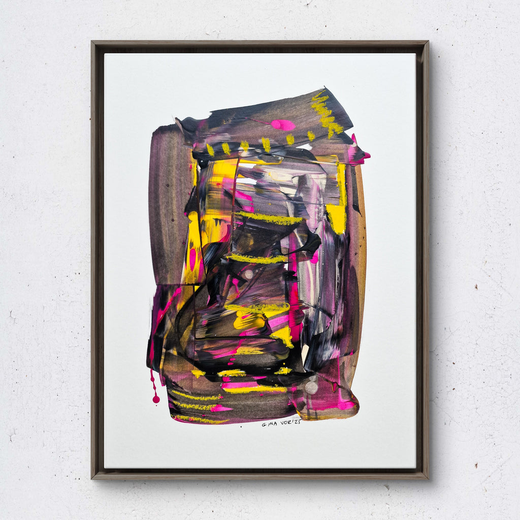 Abstract painting with vibrant colors in a black frame on a white wall