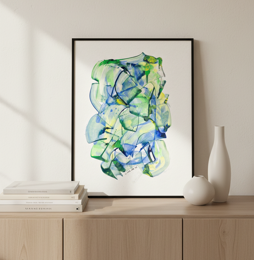 A framed abstract painting with flowing green, blue, and yellow shapes on a white background, leaning against a beige wall on a light wood cabinet beside stacked books and two white vases.
