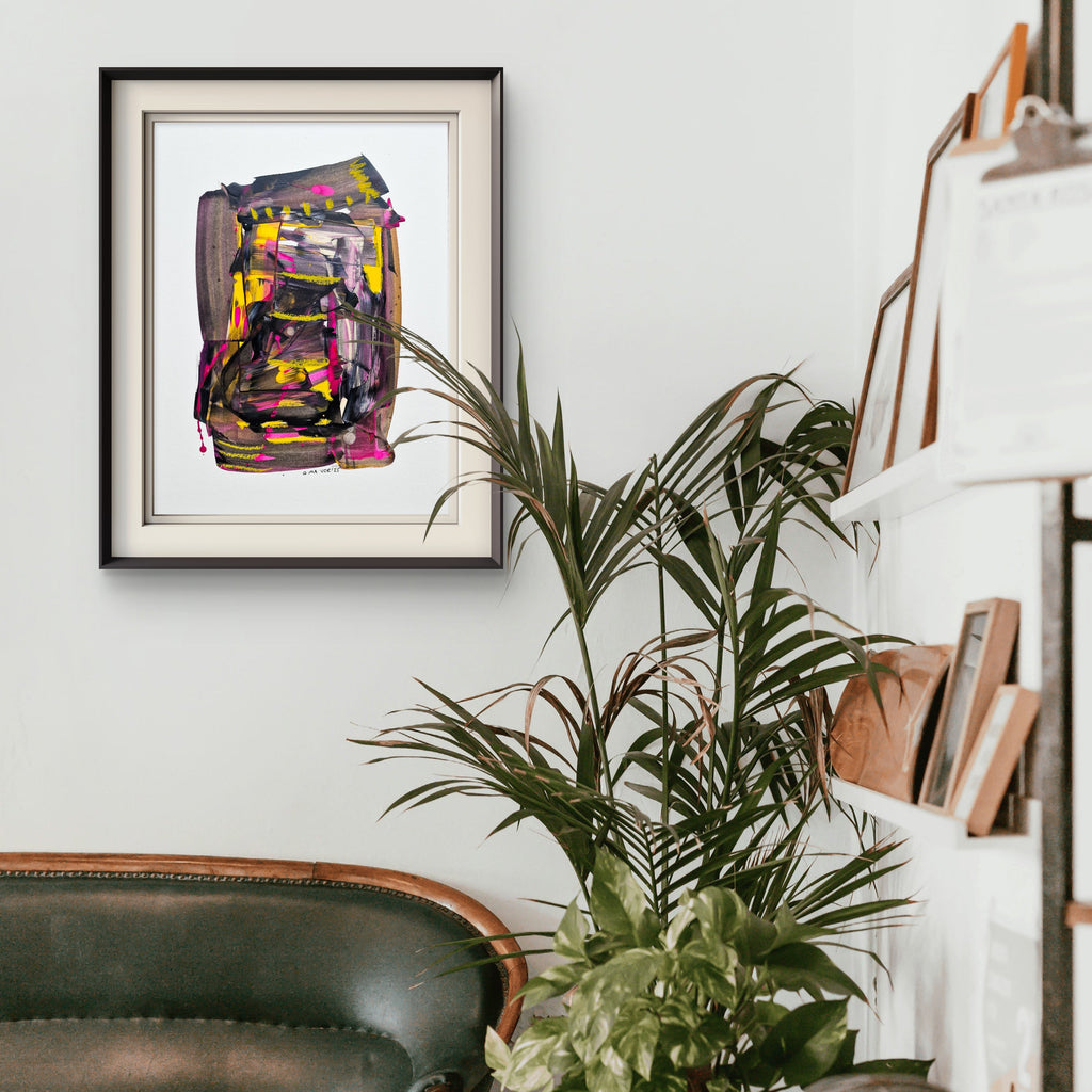 Living room with a green sofa, plant, and abstract art on the wall.