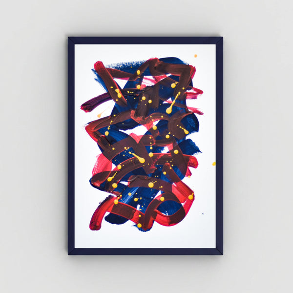 A framed abstract art featuring expressive brushstrokes in navy blue, red, and dark brown with small yellow paint splatters, set against a clean white background and mounted on a light gray wall.
