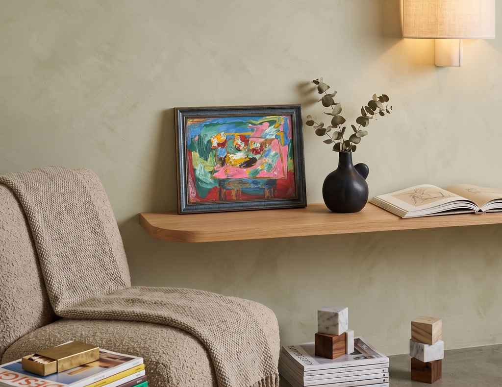 Cozy living room corner with a armchair, shelf, and decorative items.