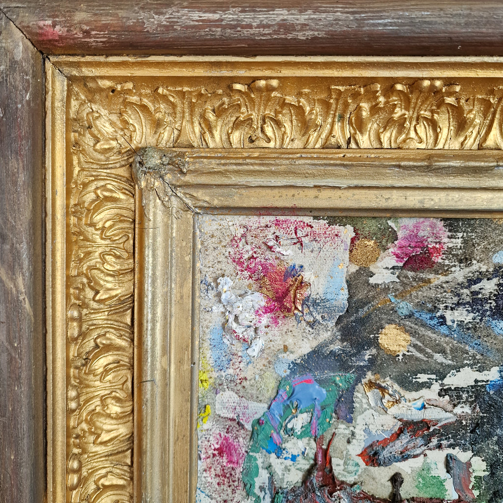 Close-up of an ornate gold and dark wood picture frame around a textured, multicolored abstract painting.