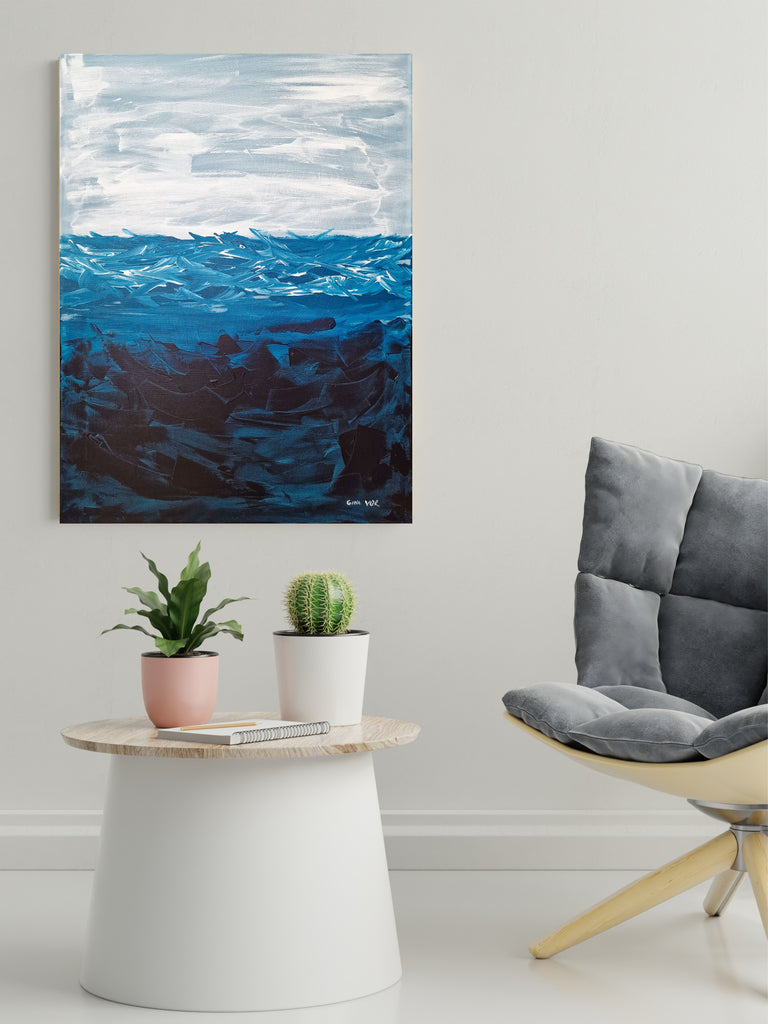 Abstract painting of ocean waves above a modern living room setup with a chair, table, and plants.