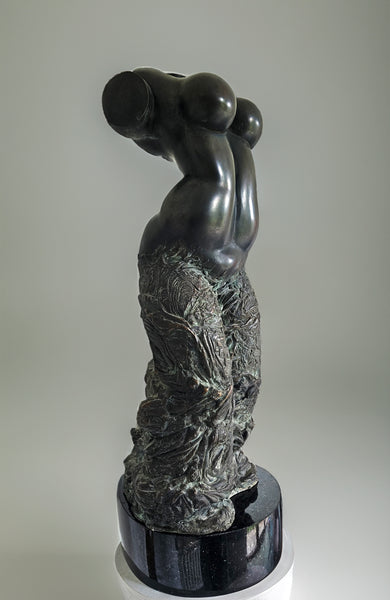 Bronze sculpture of a female dancer's torso by Aloyzas Smilingis-Elis, with smooth curves and intricate detailing on the lower half, standing on a dark base. The sculpture is headless and armless, focusing on the fluid movement and elegance of the dancer's form.