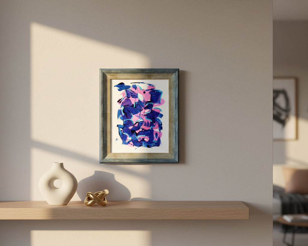 Abstract art piece with purssian blue and pink colors in a wooden frame in contemporary interior